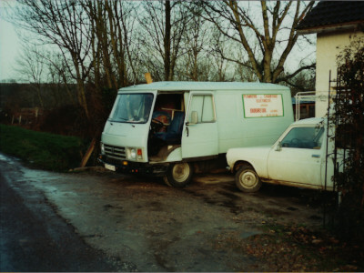 Peugeot J9 bleu ciel portant le panneau publicitaire de l'entreprise